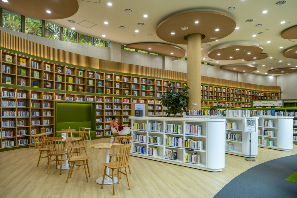 높은 층고와 푸른 숲을 형상화한 벽면서가가 돋보이는 자료실(서초구립방배숲환경도서관)